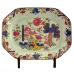 Travessa oblonga e de cantos chanfrados, em porcelana chinesa da Companhia das Índias, decorada nos esmaltes da Família Rosa em profusa decoração conhecida como Folha de Tabaco. China. Dinastia Qing. Reinado Qianlong (1736-1785). 29 x 22 cm. Peça similar reproduzida no Livro Tabaco Leaf and Pseudo Feuille de Tabac et Pseudo, de Pierre L. Demoby. Prefácio de David S. Howard. Pág. 165.