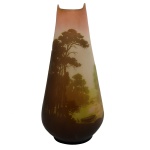 GALLÉ, ÉMILE  Vaso Art Nouveau de formato cônico com borda superior recortada, em pasta de vidro acidado trabalhado em cameo. Bojo ornamentado em tons variados de verdes, marrons e rosados, com paisagem florestal, lago e barco. Assinado. França. Séc. XIX. 46 cm.