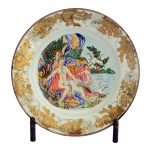 Prato em porcelana chinesa da Companhia das Índias, decorado com bordas estilizadas a ouro. Centro apresentando pintura policromada inspirada na cena mitológica de Leda e o Cisne. Prato do séc. XVIII. Cerca de 1740. 28 cm. Prato com o mesmo tema vendido pela Christies London em 2003 da coleção J. Louis Binder.