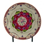 Prato em porcelana chinesa da Companhia das Índias, ornamentado em policromia de esmaltes da Família Rosa com bordas estilizadas alternando treliças e guirlandas. Centro apresentando flor de lótus e medalhão floral. Decoração feita para o mercado indiano. China. Qing. Reinado Qianlong (1736-1795). 28 cm.