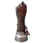 Rara figa baiana em madeira lustrada, ornamentada por unhas e largo arremate em prata lavrada com frisos em filigrano e torsades. Acompanha pulseira com amuletos. Contraste da prata baiana de teor 900 mls e marca de prateiro. 19 cm.
