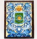 Painel de azulejos com Brasão do Império. Apresenta decoração na cor azul com folhagens e arabescos. 38 x 28,5 cm. Moldura de madeira. Apresenta um azulejo com trincado.