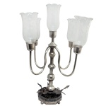 Candelabro para cinco luzes, adaptado à eletricidade, Hastes recurvas em prata batida, repuxada e alisada. Mangas em cristal. Base em granito sextavado encastoado na base, de onde partem três figuras de cisnes. 50 x 40 cm.