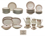 Aparelho de jantar,chá e café em porcelana da manufatura Schmidt de superfície branca, decorado com proeminente faixa de elementos florais em policromia. Composto por 03 travessas ovais (37 x 24 cm/ 33 x 22 cm/ 29 x 19 cm), 02 bowls (06 x 25 cm/ 06 x 22 cm), 01 prato p/ arroz (27 cm), 09 (pratos rasos), 12 pratos fundos, 12 pratos p/ sobremesa, bule p/ chá (19cm), bule p/ café (24cm), leiteira (17 cm), açucareiro (11 cm), manteigueira, 12 xícaras p/ café c/ pires (um pires bicado), 11 xícaras p/ chá c/ pires (seis xícaras bicadas e um pires bicado).