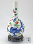 Antigo vaso em porcelana chinesa, esmaltação Wucai, decorado com dragão entre nuvens e chamas celestiais. Marca de dois caracteres no fundo. Séc. XIX. Med. 19cm. Com base: 22 cm.