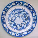 Antigo prato em porcelana chinesa, decorado com esmalte azul e relevos florais em esmalte 'Bianco Sopra Bianco'. Circa 1900. Sem marcas. Med. 25 cm.