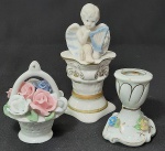 Lote com três(3) itens em porcelana sendo um vasinho, e dois castiçais um com flores e anjinho