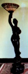 Magnifica Luminária esculpida em resina italiana, representando figura feminina, no estilo Art Nouveau, apoiada sobre coluna decorada por ramagens, em alto relevos, acompanha cúpula com vitrô no estilo TffanY. Mede: 1,95 cm por 45 cm de circunferência. Obs. Lote 113 faz um par.