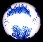 Grande esfera oriental em porcelana no tom azul cobalto, ornada por ponte com figura de grande folhas com paisagem. Mede: 14,5 cm