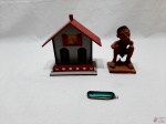 Lote composto de enfeite de casa, canivete e escultura em terracota de homem defecando. Medindo a casa 15,5cm de comprimento x 15cm de altura.