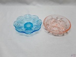 Lote de 2 petisqueiras em vidro sendo uma em vidro azul moldado com pé e uma em vidro salmão moldado. Medindo 15cm de diâmetro x 3,5cm de altura.