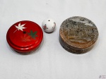 Lote composto de 2 caixas decorativas e 1 enfeite de bola em porcelana. Sendo uma das caixas em laca e uma em pedra decorada. Medindo a caixa em pedra 12,5cm de diâmetro x 4,5cm de altura.