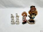 Lote de 4 enfeites, sendo 2 orientais em porcelana e 2 bonecas em resina. Medindo a maior 12,5cm de altura.