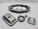 Lote diverso, composto de travessa oval, coador de chá de mesa, salva e manteigueira em aço inox. Medindo a travessa 30,5cm x 19cm x 4cm de altura.