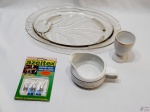 Lote composto de bandeja em vidro, molheira, dosadores de lata de azeite e copo em porcelana com friso ouro. Medindo a bandeja 37cm x 25,5cm x 4cm de altura.