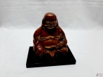 Escultura de Buda sentado em metal cobreado com base de resina. Medindo 19,5cm x 10cm a base x 16cm de altura