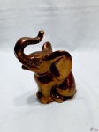 Escultura de elefante sentado em metal cobreado. Medindo 17,5cm de altura