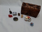 Lote diverso, composto de caixa em madeira entalhada e miniaturas decorativas. Medindo a caixa 17cm x 9,5cm x 11,5cm de altura.