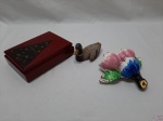 Lote composto de caixa em madeira laqueada, pato em resina e floreira para pendurar em porcelana com policromia. Medindo a caixa 17,5cm x 12,5cm x 5,5cm de altura.