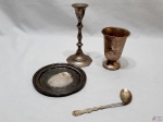 Lote composto de colher torta infantil, castiçal, descanso de garrafa e copo infantil, peças em metal prateado.  Medindo o castiçal 16cm de altura.