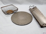 Lote diverso, composto de bandeja, descanso de panela e pãozeira em metal prateado. Medindo o descanso 24,5cm de diâmetro.