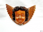 Escultura de anjo em madeira entalhada para pendurar. Medindo 33cm x 23,5cm.