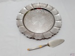 Prato de bolo em aço inox Pratinox cinzelado, acompanha espatula em aço inox Hercules.  Medindo o prato 33,5cm de diâmetro.