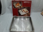 Travessa tabuleiro em aço inox Tramontina com grade para assados. Medindo 42cm x 37cm x 7cm de altura.