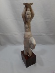 Escultura de aguadeira em porcelana com base em madeira, serve como castiçal e possui passagem para fiação de abajur. Medindo 48cm de altura.