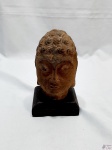 Escultura da cabeça de Buda, feita em pedra, com base em madeira. Medindo 18cm de altura total.