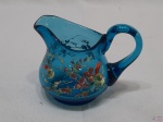 Pequena cremeira em vidro azul com pintura floral. Medindo 7cm de altura.