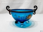 Bowl, fruteira em vidro azul pintado e acabamento em metal dourado. Medindo 17cm de diâmetro de boca x 13cm de altura. Com uma trinca interna na base.