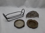 Lote composto de porta guardanapo em prata 90, suporte para petisqueira oval, salva em prata 90 e cinzeiro em bronze com relevos. Medindo o porta guardanapo 15,5cm de comprimento x 8,5cm de altura.