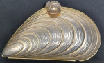 Bolsa de festa em metal dourado representando concha com pedras no fecho. Medindo 13 x 23 cm.
