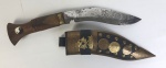 Cutelaria - Faca Kukri de caça / guerra, em aço, punho em madeira, com bainha em couro e metal dourado `Nepal`. Medindo: 24 cm. 