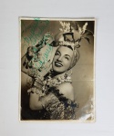 Carmen Miranda, reprodução de foto, autografada. Autenticidade não atestada. Medindo: 17 x 12,5 cm. Marcas de dobras.