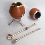 Duas cuias, duas bombas e suporte para chimarrão, uma bomba marcada prata e outra marcada alpaca. 