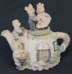 Caixa musical no formato de bule, decorada com ursos, funcionando. Medindo:13 x 17 x 14 cm.