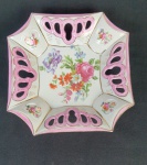 Centro de mesa em porcelana, com decoração floral, bordas vazadas e detalhes em ouro. Medindo: 5 x 21 x 20 cm.