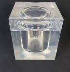 Grande e pesada geleira com tampa moldada em grosso bloco de acrílico, base com efeito de gelo condensado e interior na forma esférica. Anos 70. Medindo: 20 x 18 x 18 cm.