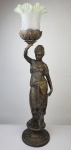 Abajur/luminária representando mulher grega sustentando tocha em bronze platinado. Medindo: 60 x 17 cm.  