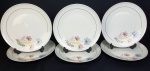 Schmidt - Seis pratos rasos em porcelana nacional na cor branca, delicada decoração floral e fio de ouro. Medindo: 26 cm. Um apresenta fio de cabelo.