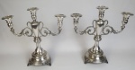Par de castiçais em metal espessurado a prata, cinzelado, para 3 velas. Medindo: 34 x 34 cm.