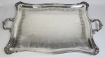 Imponente bandeja em metal espessurado à prata, com alças e laterais cinzeladas. Medindo: 95 x 41 cm.