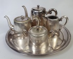 Aparelho de chá, em metal espessurado à prata, composto de dois bules, açucareiro, leiteira e bandeja. Medindo: 11 x 18 cm, 16 x 21 cm, 9 x 15 cm, 10 x 13 cm e 34 cm. Com desgaste do tempo.