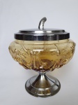 Bomboniere em vidro anos 50, na cor âmbar, base e tampa em metal prateado. Medindo: 20 x 16 cm.