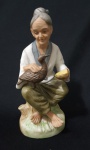 Escultura em biscuit representando anciã. Medindo: 14 x 5 cm. 