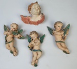 Quatro pendentes em estuque, representando anjos, sendo 3 com instrumentos. Medindo: 13 cm e 8 x 10 cm. 