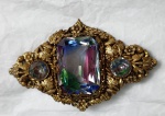 Antigo broche em metal anos 40 / 50, decorado com folhagem, flores e pedras furta-cor. Medindo: 7 x 4,5 cm.