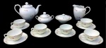 STEATITA, PARANÁ DÉCADA DE 50/60- Elegante conjunto para chá em fina porcelana, com esmaltagem vitrificada decorada por flores seguidas de bordas em curvas com realce em fio de ouro. Sendo: bule (23 x 16,5cm) leiteira(15,5 x 12,5cm), mantegueira (14 x 7,5cm) açucareiro (15 x 11cm) e 6 xícaras com pires.